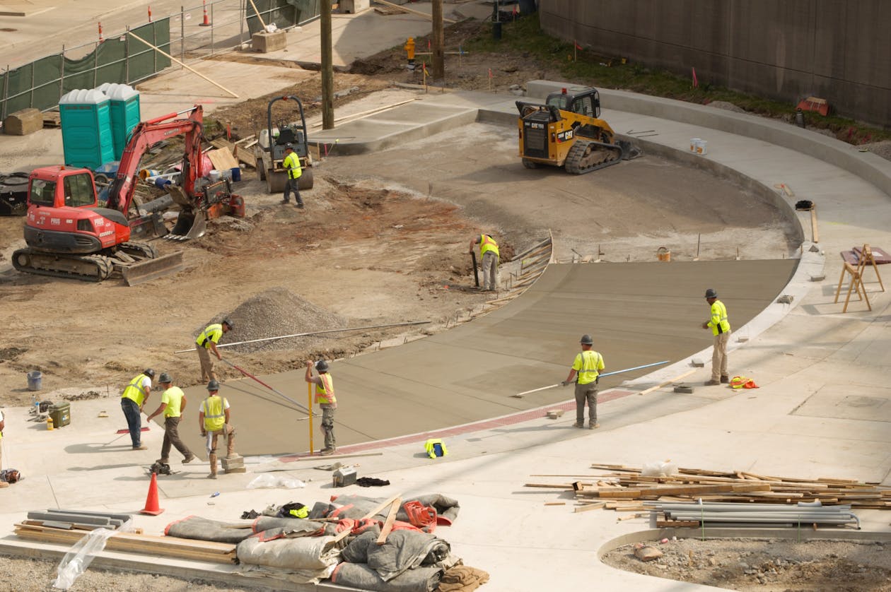 Construction workers paving concrete at a bustling site in Covington, KY. — concrete driveway epoxy coating